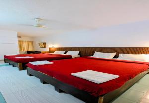 a room with three beds with red sheets at The Lantana Resorts in Madikeri +21 photos