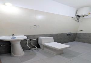 a bathroom with a white toilet and a sink at The Lantana Resorts in Madikeri
