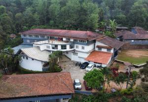 an aerial view of a house with cars parked in front at The Lantana Resorts in Madikeri