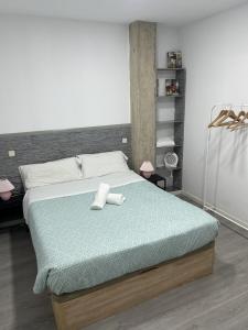 a bedroom with a bed with two towels on it at A&R Santiago de Compostela in San Sebastián de los Reyes
