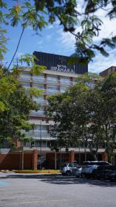 a office building with cars parked in a parking lot at Hotel Jirahara in Barquisimito +2 photos