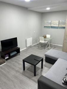 a living room with a couch and a table at A&R Santiago de Compostela in San Sebastián de los Reyes