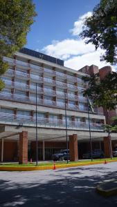 a large building with cars parked in front of it at Hotel Jirahara in Barquisimito