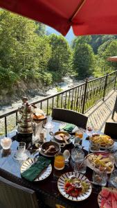 a table with food on it with a view of a river at Yesilvadi Otel 4M LUXURY in Ayder Yaylasi