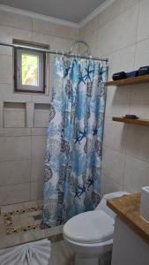 a bathroom with a toilet and a shower curtain at SEMEREL APARTMENT in Palm-Eagle Beach +18 photos