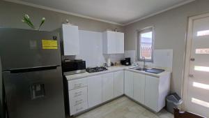a kitchen with white cabinets and a refrigerator at SEMEREL APARTMENT in Palm-Eagle Beach