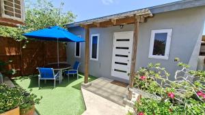 a patio with a table and a blue umbrella at SEMEREL APARTMENT in Palm-Eagle Beach