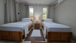 two twin beds in a room with a window at SEMEREL APARTMENT in Palm-Eagle Beach