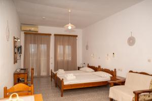a bedroom with two beds and a couch at Jimmy Anna Apartments in Votsalákia