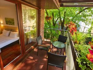 a room with a balcony with a bed and chairs at HOME Apart-Hotel Vilnius in Vilnius