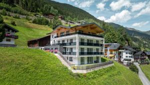 a large white building on a hill in a village at Lerch Suites in Kappl