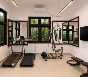 a gym with treadmills and ellipticals in a room at Dhanora Dynasty Resort in Anuradhapura