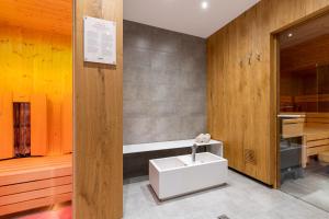 a bathroom with a white sink and a tub at Lerch Suites in Kappl +56 photos