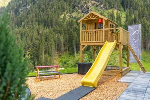 a playground with a slide and a bench at Lerch Suites in Kappl