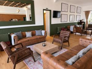 a living room with couches and chairs and a table at Dos Romeiros in Palas de Rei