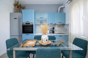 a kitchen with a glass table and blue cabinets at Vila Petro in Evkarpía