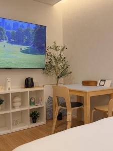 a living room with a table and a tv on the wall at 무무 mumu in Seoul