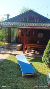 a house with a picnic table and a bluearp on the grass at Fa-mìlia Vendègház in Tiszavasvári +2 photos
