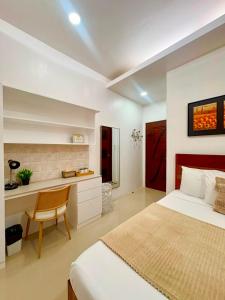 a bedroom with a bed and a desk in it at Ramz Residence in El Nido