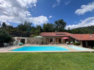 a house with a swimming pool in the yard at Casa dos Cinco - Gerês in Terras de Bouro