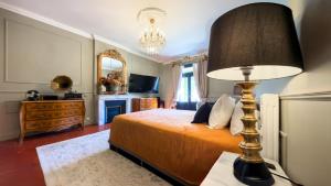 a bedroom with a bed with a lamp on a table at Le 215 Gambetta boutique hôtel en Provence in Cavaillon