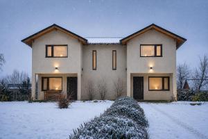 a large house in the snow with lights on at Jardin de Estepa Il in Dina Huapi