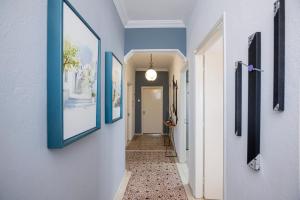 a hallway with blue framed pictures on the walls at Vila Petro in Evkarpía