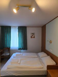a bedroom with two beds and a green window at Hotel Zur Buche 24h Check-in, Free in Bockhorn