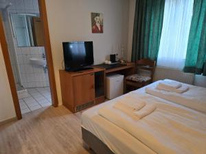 a bedroom with a bed and a tv and a bathroom at Hotel Zur Buche 24h Check-in, Free in Bockhorn +26 photos