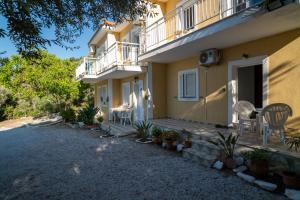 a house with a patio and a table and chairs at Jimmy Anna Apartments in Votsalákia