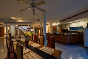 a dining room with a table with a ceiling fan at Amber Pool Villa Your private slice of paradise in Rawai Beach