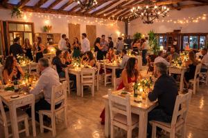 a group of people sitting at tables in a restaurant at Hotel Casa De Campo in Santa Cruz