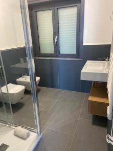 a bathroom with a toilet and a sink at Fra Rooms in Taormina