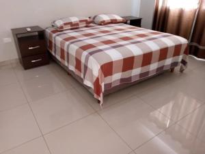 a bedroom with a bed with a checkeredkered blanket at Casa Barcelona in Santa Cruz de la Sierra