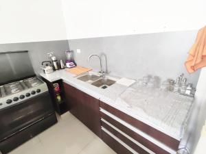 a kitchen with a sink and a stove at Casa Barcelona in Santa Cruz de la Sierra