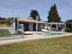 a villa with a swimming pool and a house at Avithos Blue Villas in Svoronata