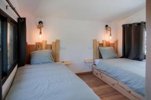 a room with two beds in a room at Les Tiny d'Aureilhan avec Jacuzzi privatif in Aureilhan