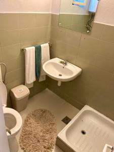 a small bathroom with a sink and a toilet at Erdei weekend ház in Jögödfürdő