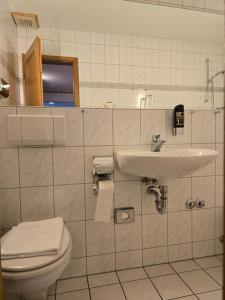 a bathroom with a toilet and a sink at Hotel Zur Buche 24h Check-in, Free in Bockhorn