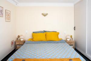 a bedroom with a large bed with yellow pillows at La Soleillade in Manosque