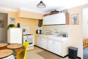 a kitchen with white cabinets and a table at La Soleillade in Manosque