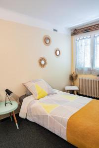 a bedroom with a bed and a table and a window at La Soleillade in Manosque +6 photos