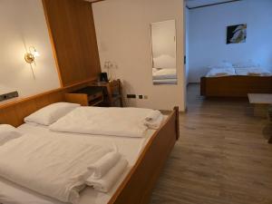 a bedroom with two beds with white towels on them at Hotel Zur Buche 24h Check-in, Free in Bockhorn