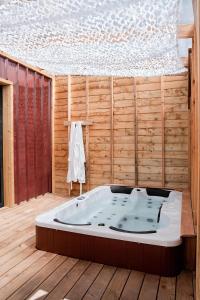 a jacuzzi tub sitting in a wooden room at Les Tiny d'Aureilhan avec Jacuzzi privatif in Aureilhan +75 photos
