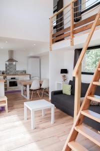a living room and dining room with a loft at Les Tiny d'Aureilhan avec Jacuzzi privatif in Aureilhan