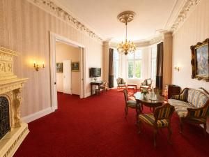 a living room with a fireplace and red carpet at Hotel Kaiserhof in Lübeck