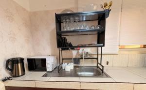 a kitchen counter with a sink and a microwave at Le nid des Anges in Yaoundé +11 photos