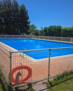 a large blue swimming pool with a red sign on a fence at El Mirador de Mesones in Mesones de Isuela