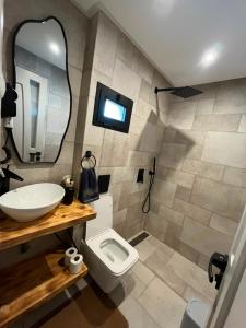 a bathroom with a sink and a toilet and a mirror at appartemment essaouira in Essaouira