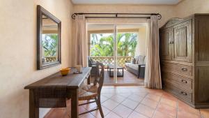 a dining room with a table and chairs and a living room at Las Mañanitas LM C208 in San José del Cabo